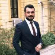 A man in a suit is posing in front of a building, representing the professionalism of contact center operations.