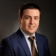 A man in a suit and tie is posing for a photo at a contact center operation.